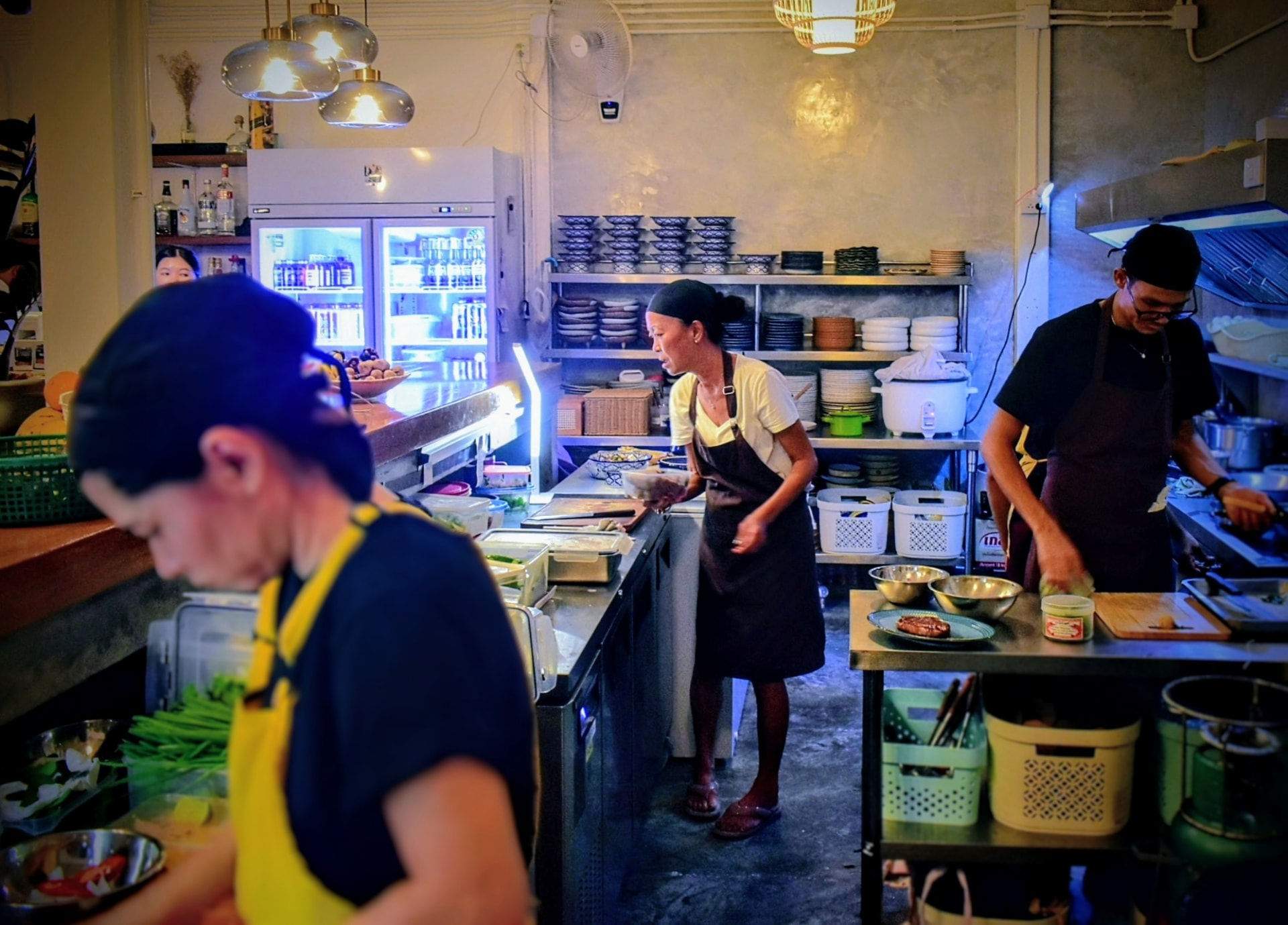 Chef P.oy and her team plating dishes in the open kitchen