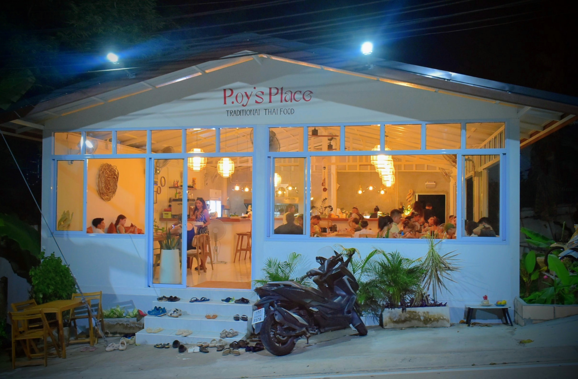 Front view of P.oy's Place lit up at night